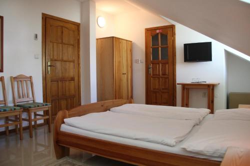 a small bedroom with a bed and a chair at Sabbia Ristorante - Reštaurácia a Ubytovanie Prievidza in Prievidza