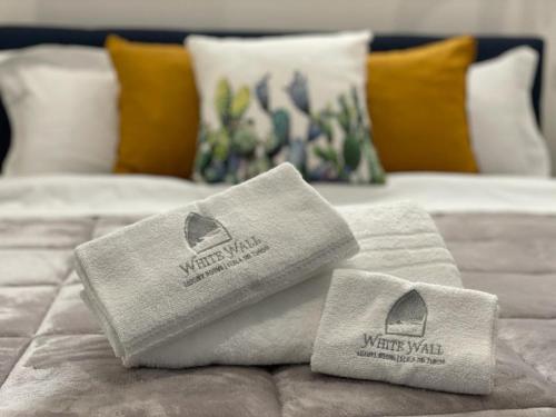 two towels sitting on top of a bed at White Wall luxury rooms Scala dei turchi in Realmonte