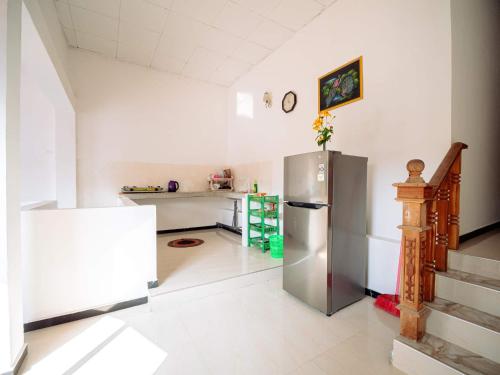 a kitchen with a stainless steel refrigerator in a room at Surfing Guest House in Matara