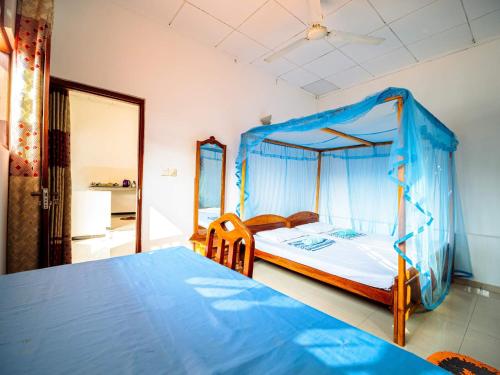 a bedroom with a canopy bed with a blue sheet at Surfing Guest House in Matara