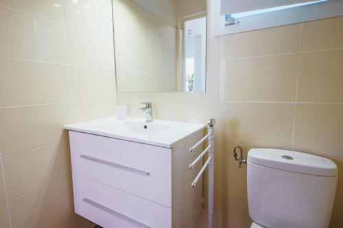 biała łazienka z umywalką i toaletą w obiekcie Villa Z'EPICES-MARINA C0NCIERGERIE w mieście Saint-François