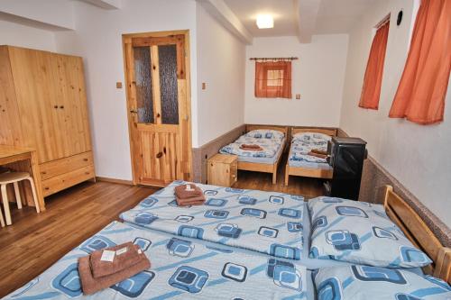 a bedroom with two beds and a wooden floor at Strnadovský mlýn in Jesenice