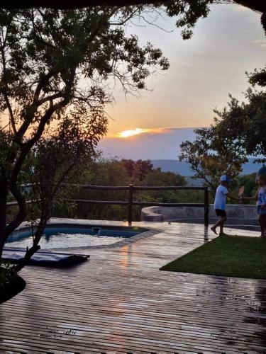 a couple of people walking by a swimming pool at Livingstone Bush Lodge, Mabalingwe in Bela-Bela
