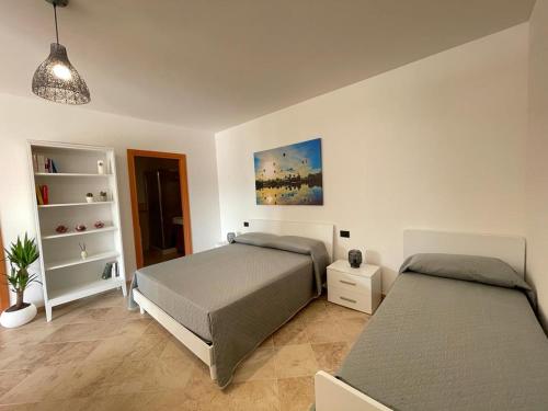 a bedroom with two beds and a book shelf at La scelta giusta in Custonaci