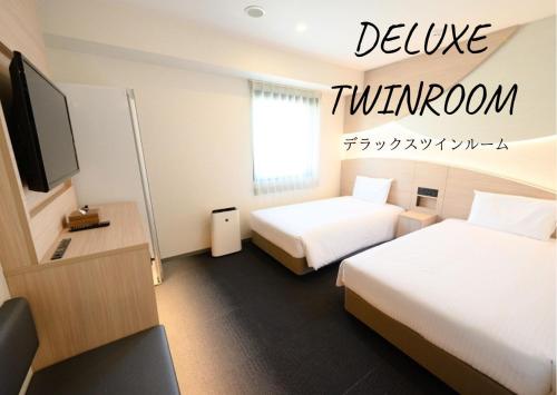a hotel room with two beds and a television at Henn na Hotel Premier Tokyo Asakusa Tawaramachi in Tokyo
