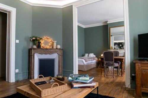 a living room with green walls and a fireplace at LES BC BG in Charleville-Mézières