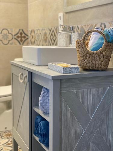 La salle de bains est pourvue d'une coiffeuse avec lavabo et d'un panier. dans l'établissement La maison du Château, à Esparron-de-Verdon