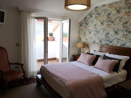 a bedroom with a large bed with pink pillows at Atico C&E Cambados in Cambados