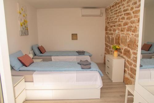 a room with two beds and a brick wall at Rural Villa Olive Krka- 30 min from sea, private pool, free parking, wifi, family friendly, park Krka 10 min in Ljubotić