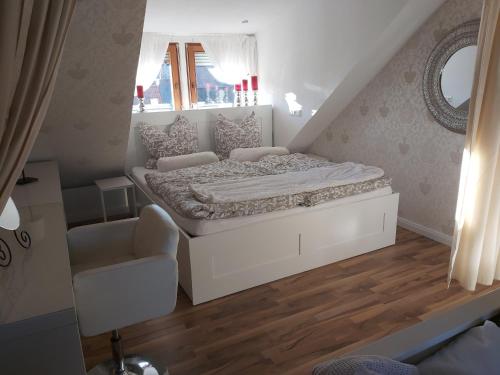 a small bedroom with a bed and a chair at Unterkunft Mitten im schönen Frankenland in Buchbrunn