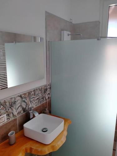 a bathroom with a white sink and a mirror at suite room malpensa b&b in Cardano al Campo
