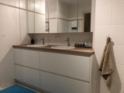 ein Badezimmer mit zwei Waschbecken und einem Spiegel in der Unterkunft MIRAMAR Zeedijk 168 Blankenberge in Blankenberge