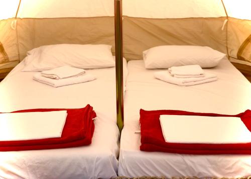 two beds with white and red pillows on them at Camping Kato Alissos in Káto Alissós