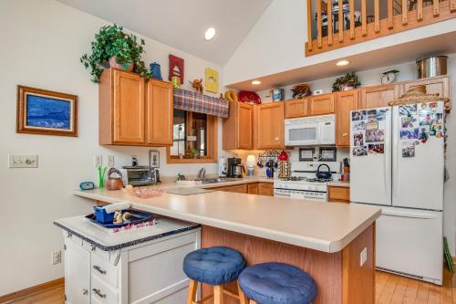 a kitchen with wooden cabinets and blue stools at RTLCMP Lakehouse in Arbor Vitae