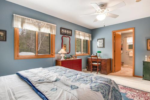 a bedroom with blue walls and a bed and a desk at RTLCMP Lakehouse in Arbor Vitae