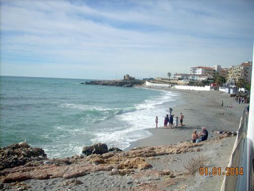 a group of people on a beach near the ocean at Apartamentos StarNerja II in Nerja