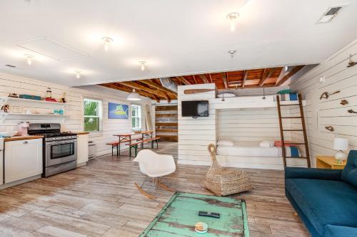 un salon avec un canapé bleu et une cuisine dans l'établissement That Place Cottage A, à Folly Beach