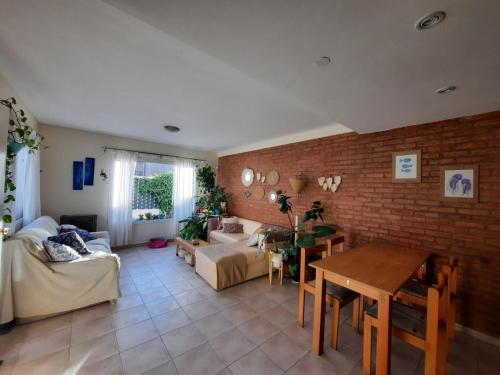 sala de estar con pared de ladrillo en Franca del mar -casa compartida- en Puerto Madryn