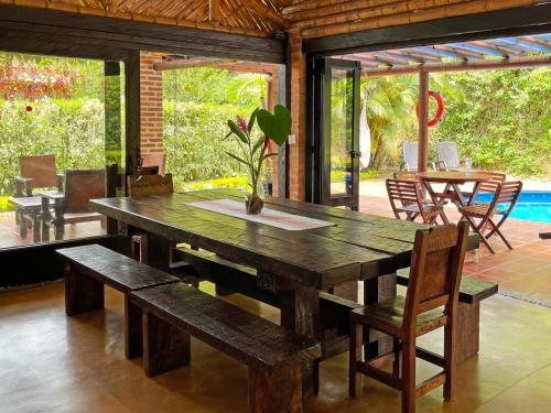 een houten tafel en bank in een kamer met een patio bij Fincas Panaca HERRERÍA 7 Grupo VIP in Quimbaya