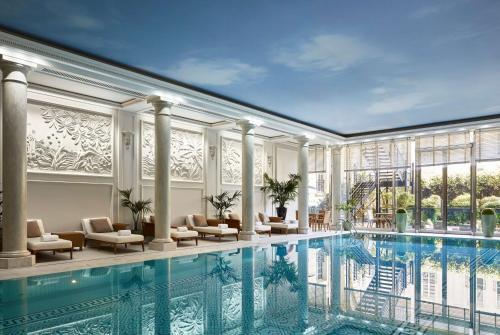 a hotel room with a pool, tub, and chairs at Shangri-La Paris in Paris