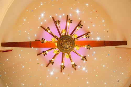 a chandelier hanging from a ceiling with stars at Hotel & Restauracja Okrąglak in Chęciny