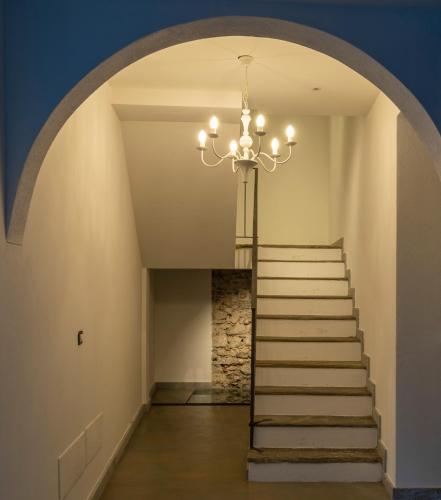 a hallway with a staircase with a chandelier at Residence Casa Coppa Appartamento Duplex in Omegna