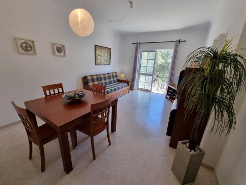 a dining room with a table and a potted plant at Apartamento Praia de Altura by Homekeys in Altura