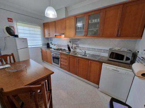 a kitchen with wooden cabinets and white appliances at Apartamento Praia de Altura in Altura