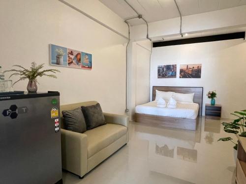 Zimmer mit einem Bett, einem Sofa und einem Stuhl in der Unterkunft Luka House in Lam Luk Ka