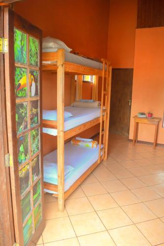 two bunk beds in a room with a window at Leo's Clan Beach Hostel in Paraty