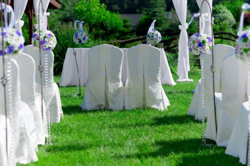 a row of white chairs in the grass at Hotel & Restauracja Okrąglak in Chęciny