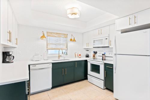 a kitchen with white appliances and green cabinets at Cocoa Beach Club in Cocoa Beach