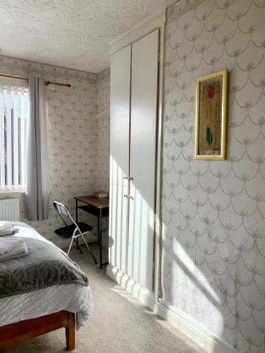 a bedroom with a bed and a desk in it at EXQUISITE FOLK VICTORIAN ONE-BED HOUSE: in Leeds