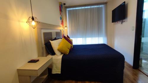 a small bedroom with a bed and a window at Hotel Aristo Gold in Tunja