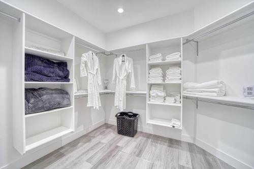 a walk in closet with white cabinets and shelves at Twin Falls Modern Retreat in Twin Falls