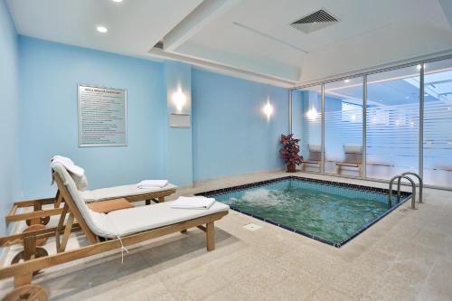 a swimming pool with a bench and a chair next to it at Eliz Hotel Convention Center Thermal Spa & Wellnes in Ankara
