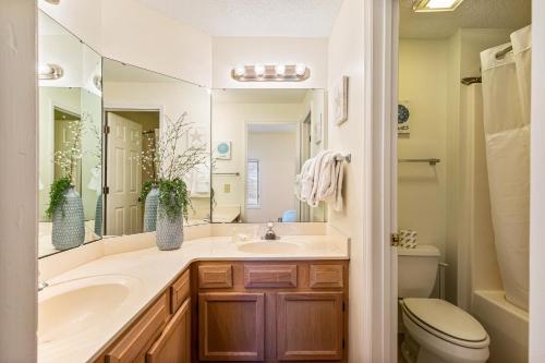 a bathroom with a sink and a toilet and a mirror at Tidewater Condos in North Myrtle Beach