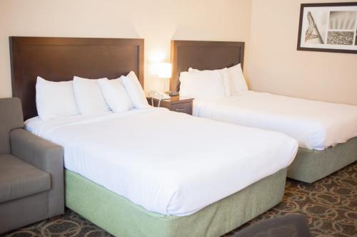 a hotel room with two beds and a chair at Inn at the Canyons in Monticello