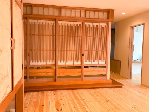 a room with glass doors and a room with wooden floors at Oceanview 貸別荘Hosuikan in Shiraoi