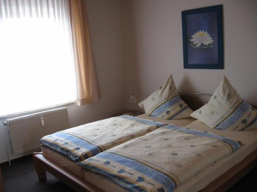 1 cama en un dormitorio pequeño con ventana en Ferienhaus Tobie, en Ahlefeld