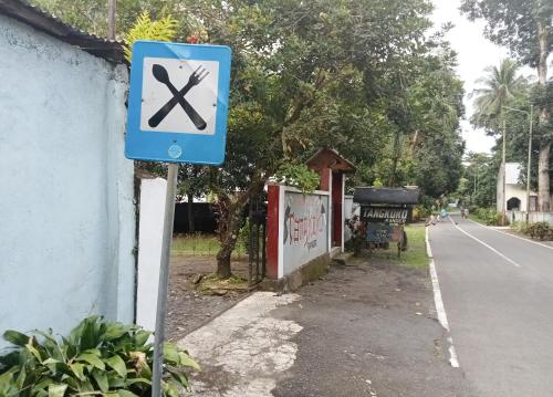 a blue sign with a x on it next to a street at Tangkoko Ranger Homestay in Bitung