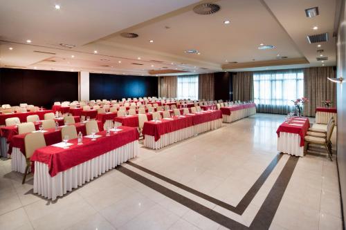 a large banquet hall with red tables and chairs at Exe Oviedo Centro in Oviedo