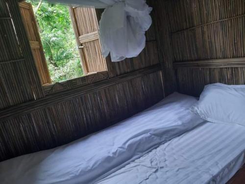 an empty bed in a room with a window at Mama Gia Homestay in Sa Pa