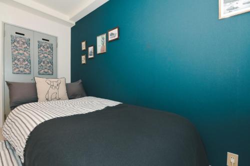 a bedroom with a bed with a blue wall at Florish 67 - Vacation STAY 15424v in Sapporo