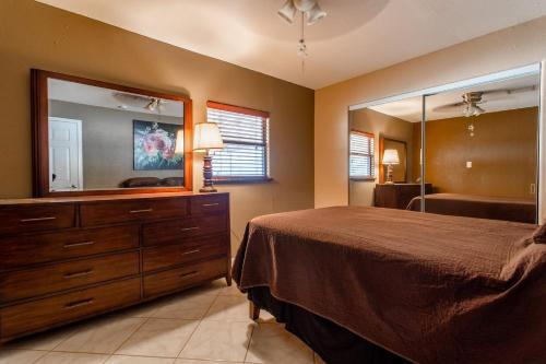 a bedroom with a bed and a dresser with a mirror at Desert Gem in Twentynine Palms