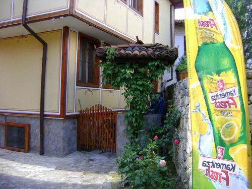 a building with a large bottle of schnitzel next to a house at Guest House Todorini kashti in Koprivshtitsa