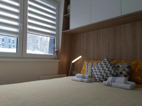 a bedroom with a bed with two pillows and a window at Bjelašnica Vukov Vis 09 - apartment with a bedroom in Bjelašnica