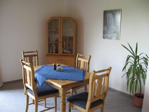 a dining room table and chairs with a blue blanket on it at Ferienhaus Tobie in Ahlefeld