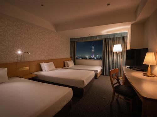 a hotel room with two beds and a window at Tobu Hotel Levant Tokyo in Tokyo