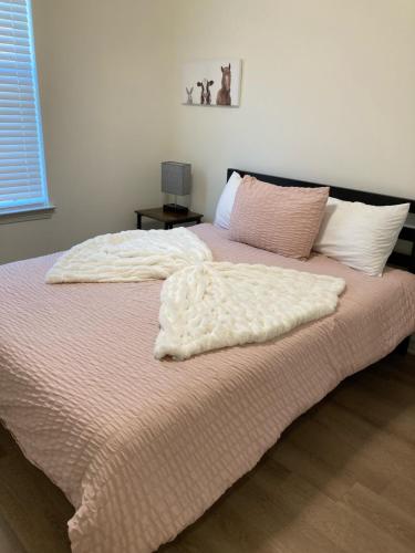 a bed with two pillows on it in a bedroom at Alamo Luxury Living up to 11 in Tyler